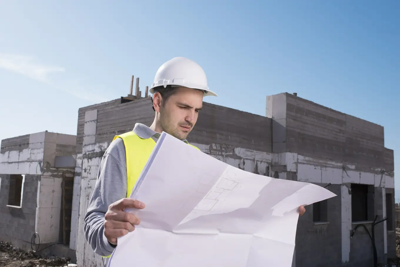 inżynier na placu budowy patrzący na plany